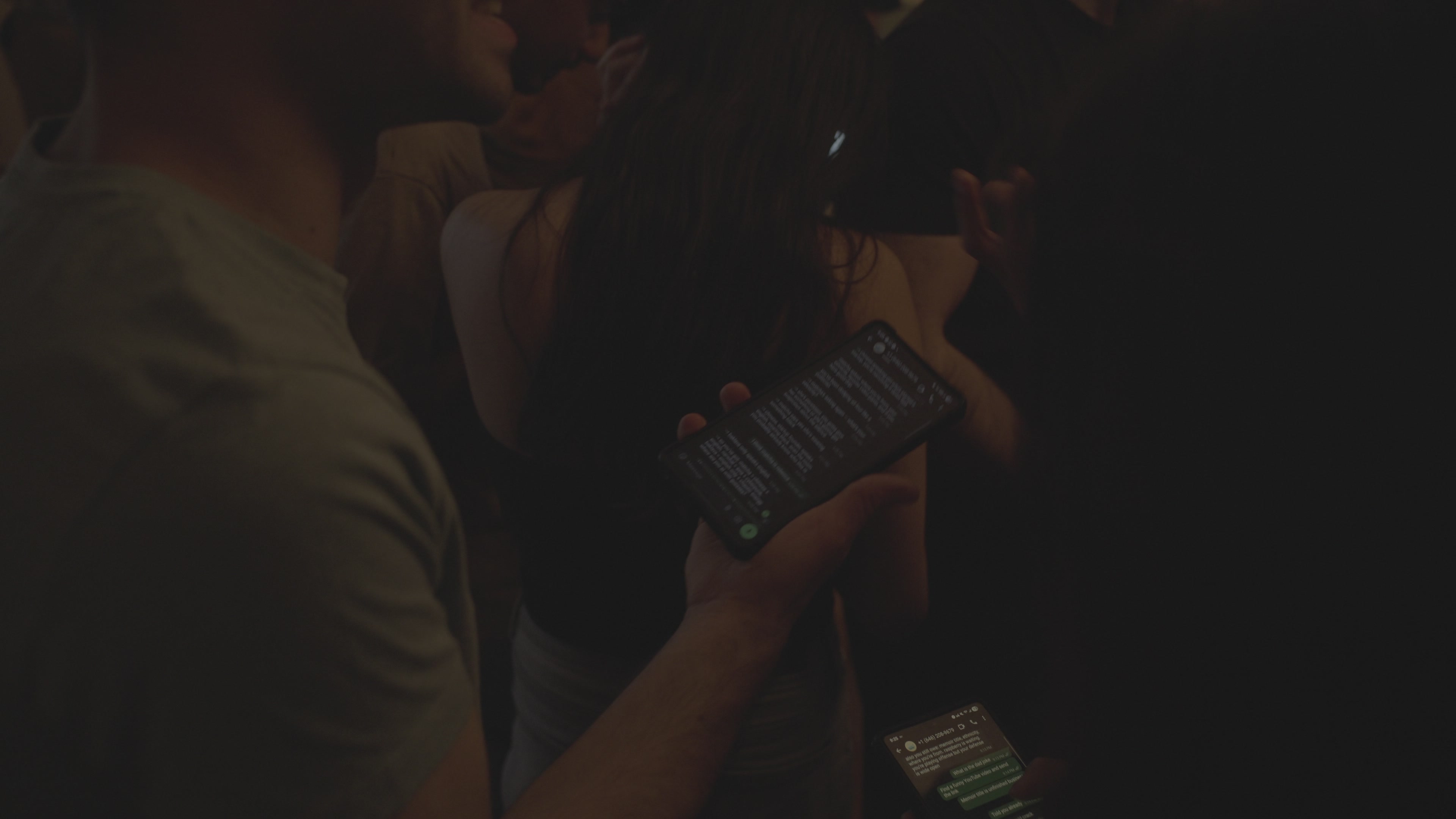 A phone held up in the dark, the game chat glowing on it