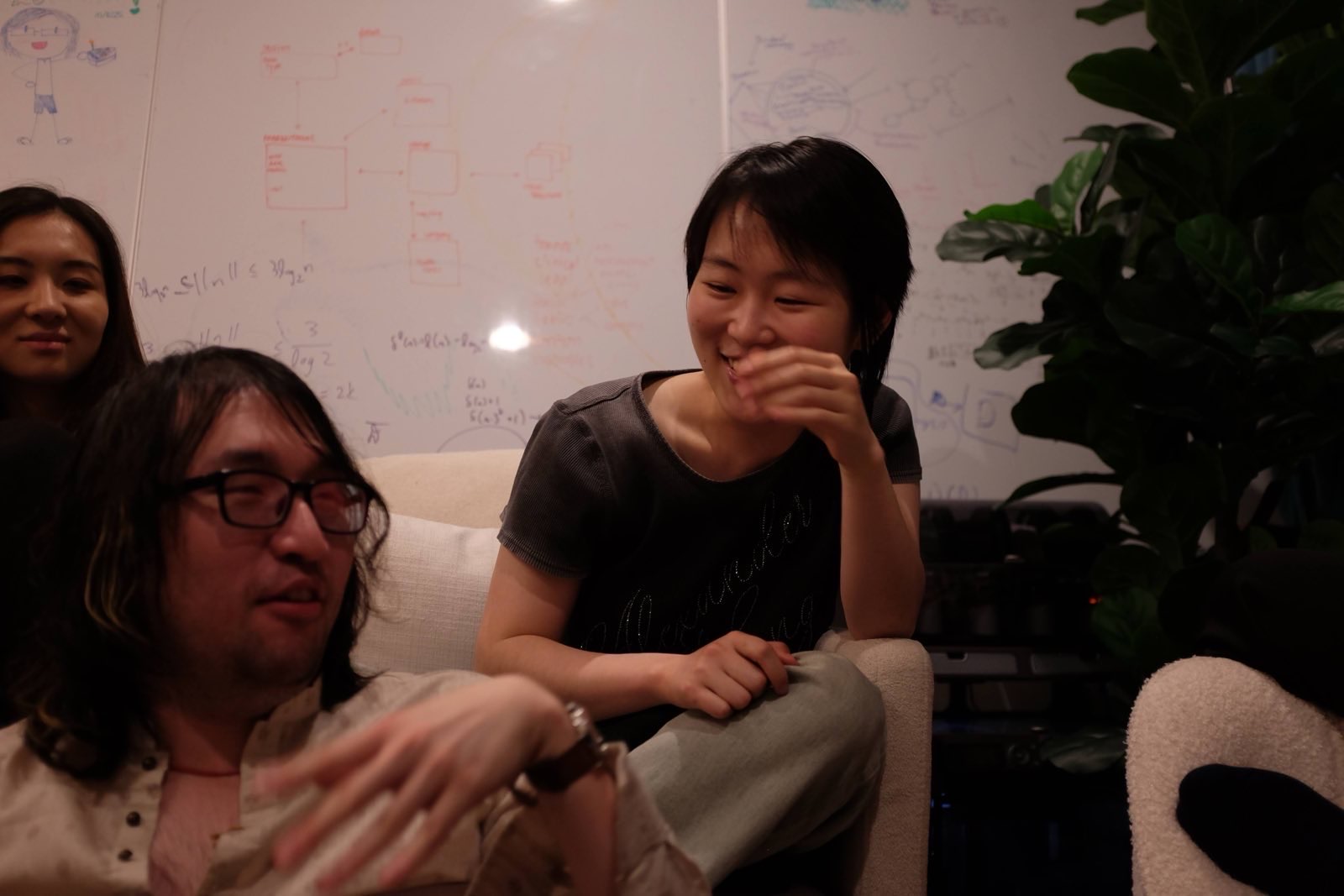 People cracking up in front of a whiteboard covered in real math